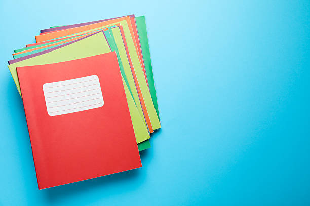 istock Stack of colorful copybooks on light blue background, top view. Space for text 2241350682