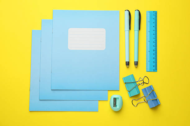 istock Flat lay composition with copybooks and other school stationery on yellow background 2241350718