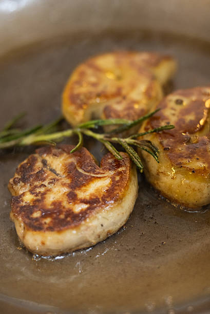 istock Sizzling pan-seared foie gras with fresh thyme sprigs in a hot skillet, creating a rich, aromatic French gourmet delicacy 2241353691