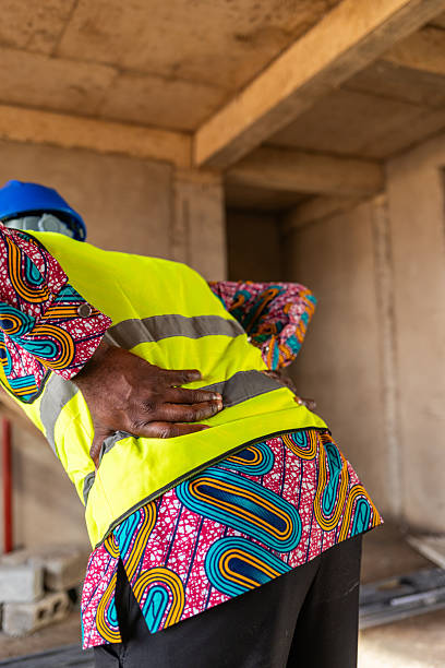istock African construction worker clutches his aching lower back on a job site, workplace injury and pain 2241353700