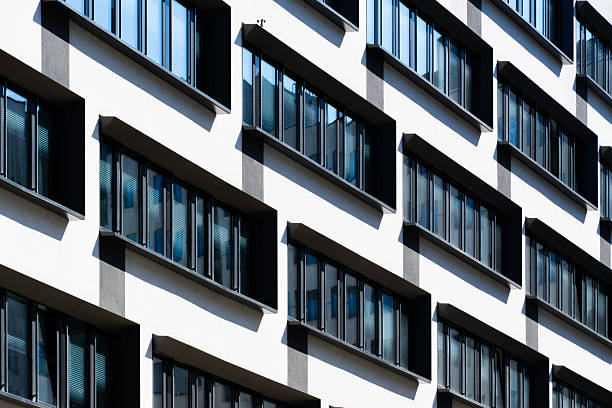 istock Contemporary office building with vertical window rhythm and clean white facade under clear bright blue sky 2241356891