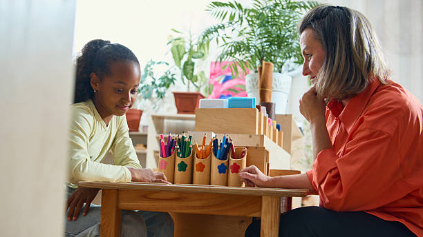 istock Teacher guiding child in creative classroom activity for psychological support 2241359561