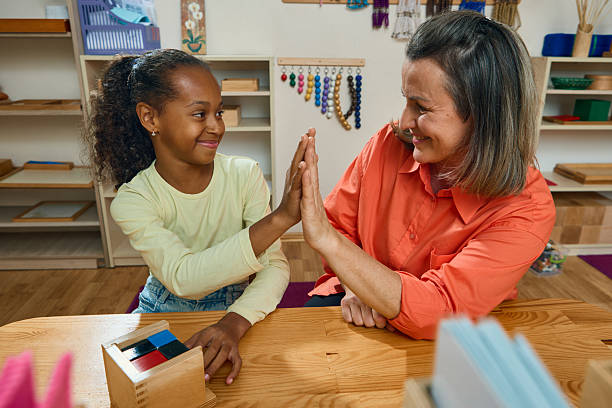 istock Teacher and child celebrating success with high five after learning task 2241359562