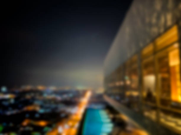 Burred a balcony overlooking an illuminated cityscape under a twilight sky. Blurred room