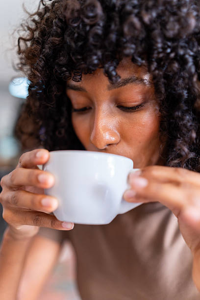 istock Young woman enjoying a warm drink with closed eyes 2241362475
