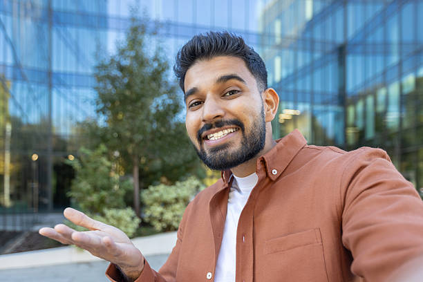 istock An enthusiastic man gestures while smiling during an outdoor video call near a modern building. 2241365211