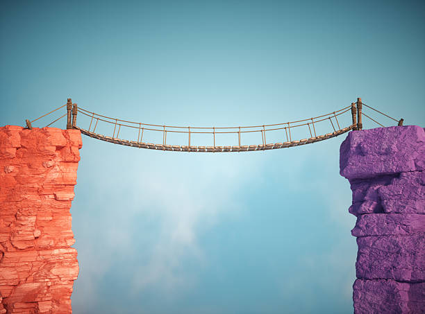 istock Creative suspension bridge connects two colorful rock formations in bright blue sky during daylight 2241367917