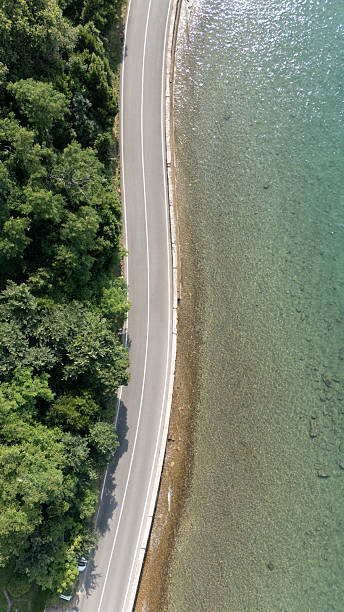 istock Curved Road in Aerial Landscape Between Forest and Sea 2241370344