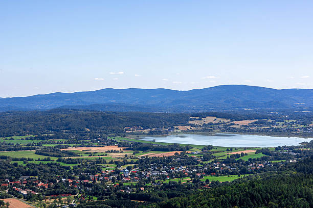 istock Vast landscape featuring mountains, lake, and fields under clear sky 2241371500
