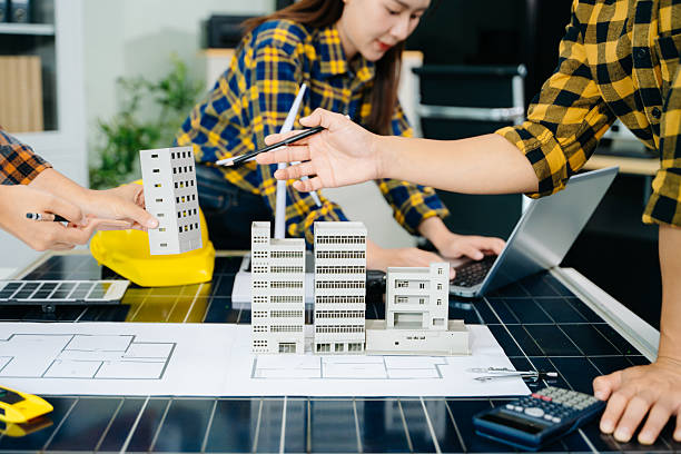 istock Construction team shake hands greeting start new project plan behind yellow helmet on desk in office to consults about their building project 2241371647