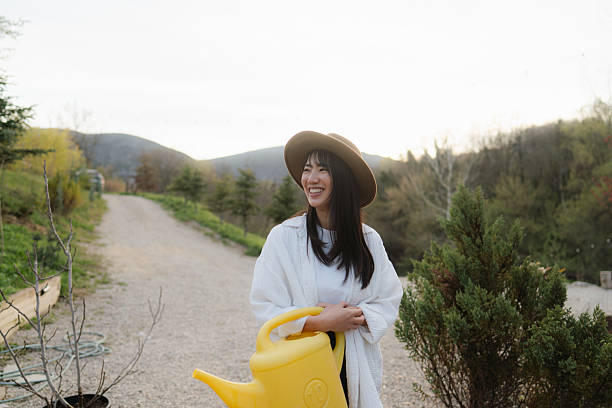 Photo of a young Asian woman watering her organic garden