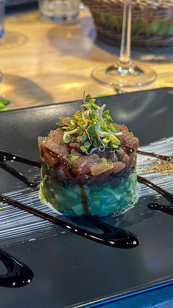 Tuna tartare on avocado puree, garnished with microgreens and balsamic dressing