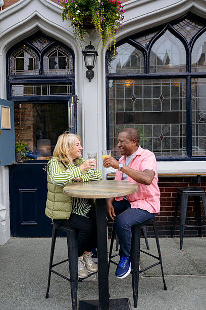 istock Cheerful senior couple sitting outside pub toasting soft drinks 2241374726