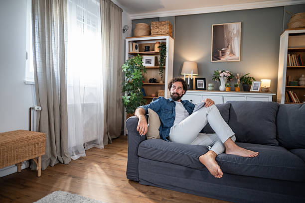 istock Man relaxing on couch at home with tablet 2241375877