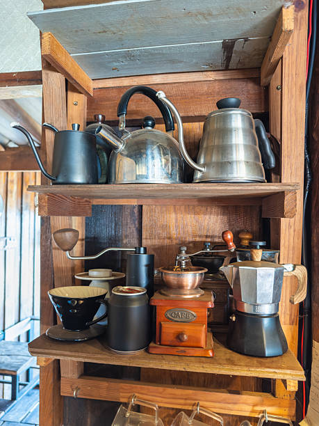 istock An array of artisanal coffee brewing tools displayed neatly on rustic wooden shelves. This collection features various kettles, manual grinders, a Moka pot, and pour-over equipment, highlighting a 2241377439
