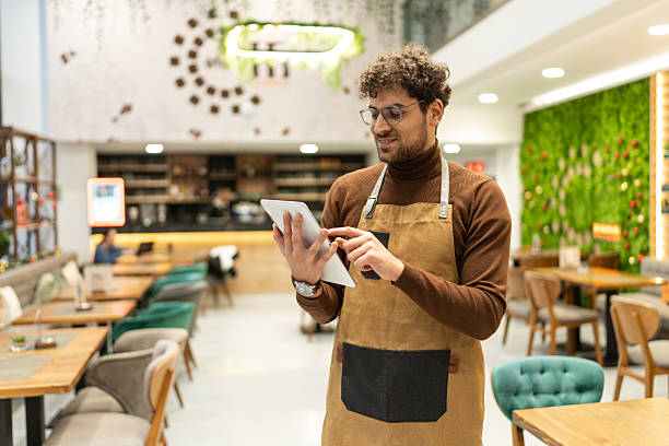 istock Cafe owner managing small business using digital tablet 2241378589
