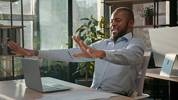 istock Successful businessman African American business man finish computer work end online project close laptop job done pause freedom break relaxing in office stretching hands arms stretch resting relax 2241379011