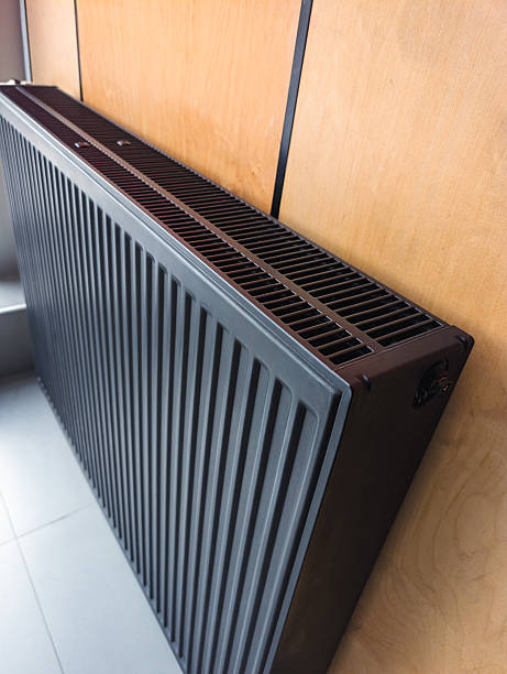 istock close-up of a modern black vertical heating radiator on a wooden wall 2241380340