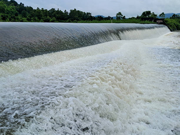 istock Dam Spillway and Waterfall Flowing into Reservoir Under Dramatic Cloudy Sky. 2241382718