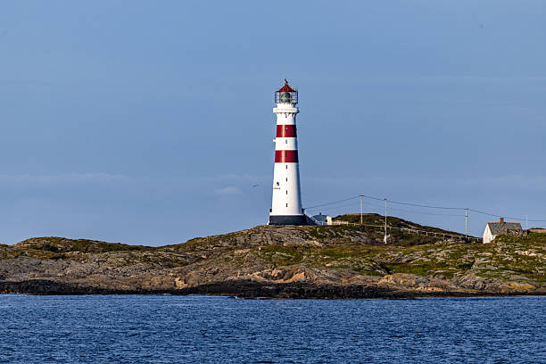 istock Majestic Red and White Lighthouse Against Tranquil Blue Sky and Sea 2241382889