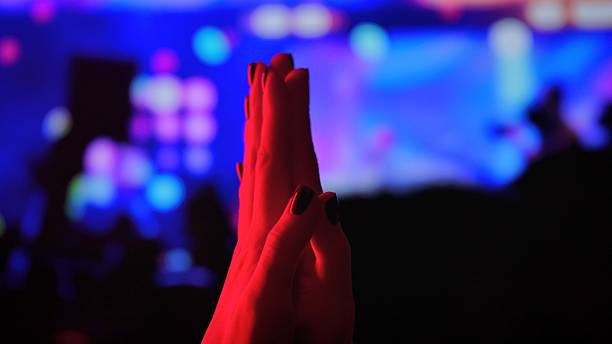 istock Applause at a concert with colorful bokeh lights 2241383311
