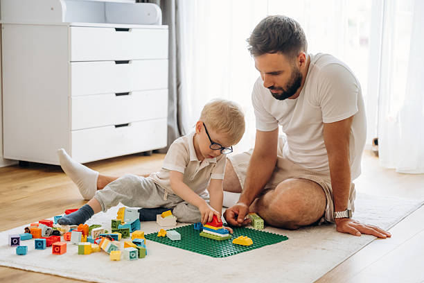 istock Having a great weekend. Father is playing in the room with his little son with construction sets 2241385144