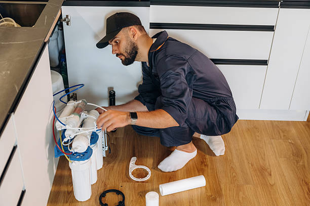 istock Installing new filters. Plumber working in the kitchen under the sink 2241385729