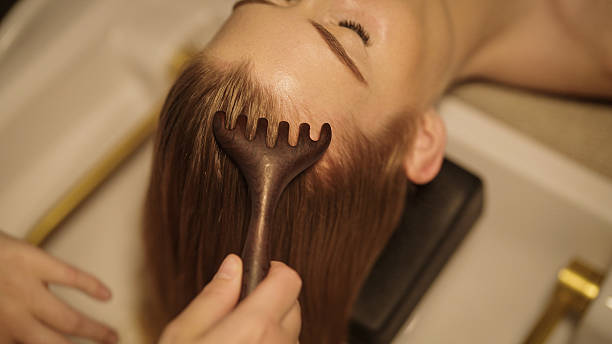 istock Hands massage head with comb. Woman relaxes in head spa. 2241387657