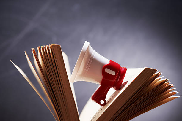 istock small megaphone resting in between of open book 2241388036