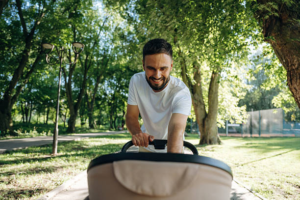 istock Very happy, parenting conception. Father is with cradle, having a walk in the park 2241388095