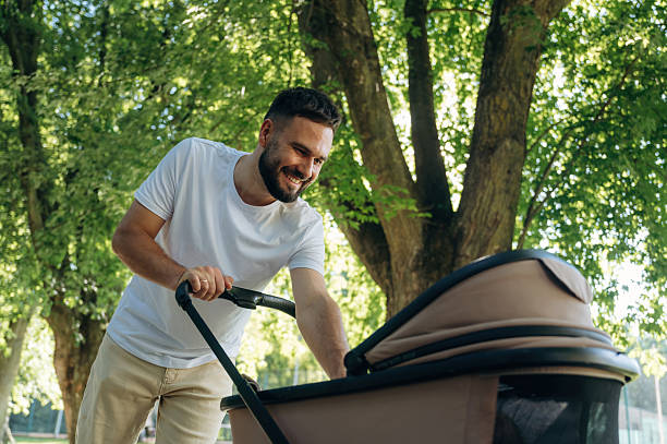 istock Very happy, parenting conception. Father is with cradle, having a walk in the park 2241388117