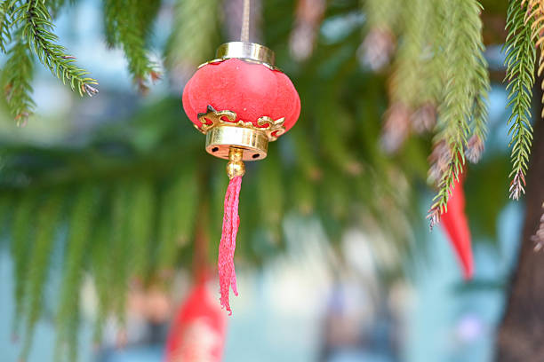 Cute and colorful Chinese New Year charms sway on the branches, representing good fortune and positive energy.
