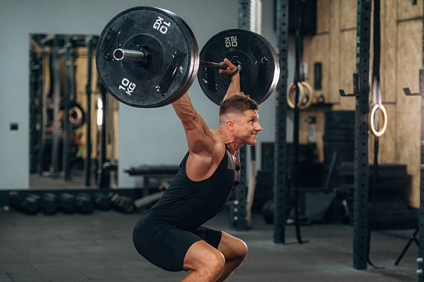 istock Proper technique, doing squats. Athletic man performing weightlifting exercises with a barbell in a gym 2241391272