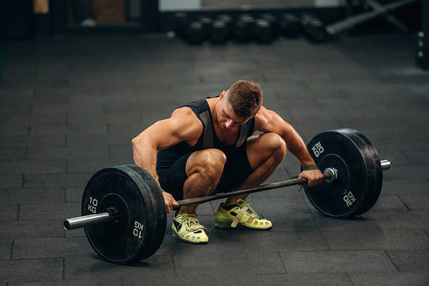 istock Getting ready. Athletic man performing weightlifting exercises with a barbell in a gym 2241391309
