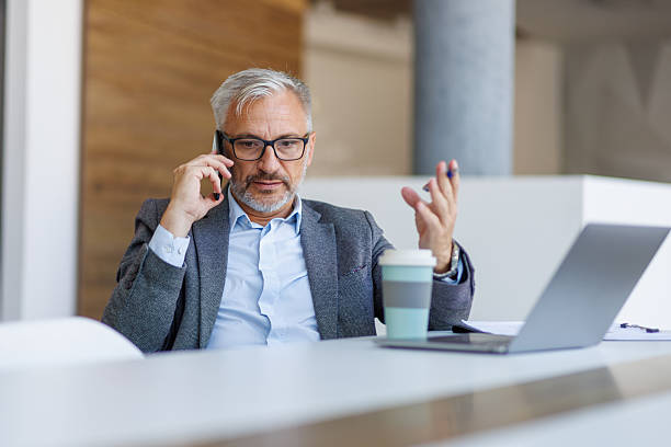 istock Mature businessman having phone call, working in office 2241391524