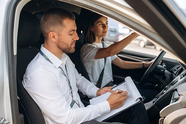 istock Side view. Woman is with instructor in car, driving school concept 2241396773