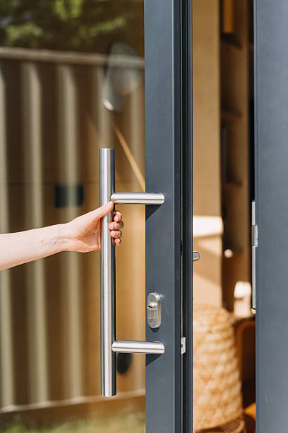 istock Modern front door with transparent glass and stainless steel handle being opened 2241399011