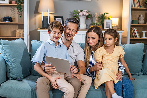 istock Family enjoying leisure time at home using digital tablet 2241400957