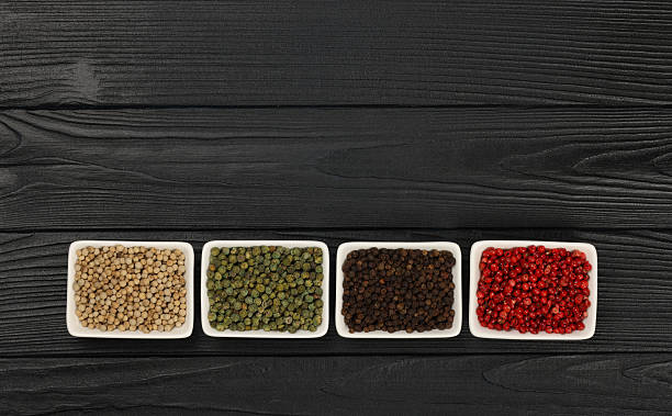 istock Peppercorns assortment displaying spices on black wooden background 2241402035