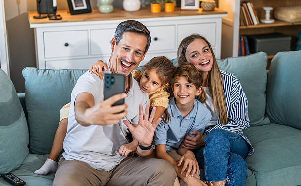 istock Family taking selfie on sofa during video call 2241402823