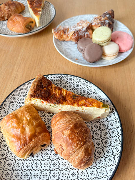 istock French breakfast table with croissants, chocolate pastries, quiche slice, and colorful macarons served on patterned plates 2241402874