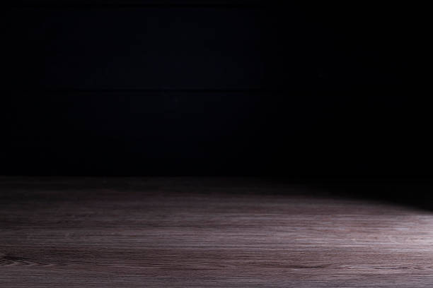 istock Old brown wooden floor or empty table with light coming from behind on a black and dark background. 2241403922