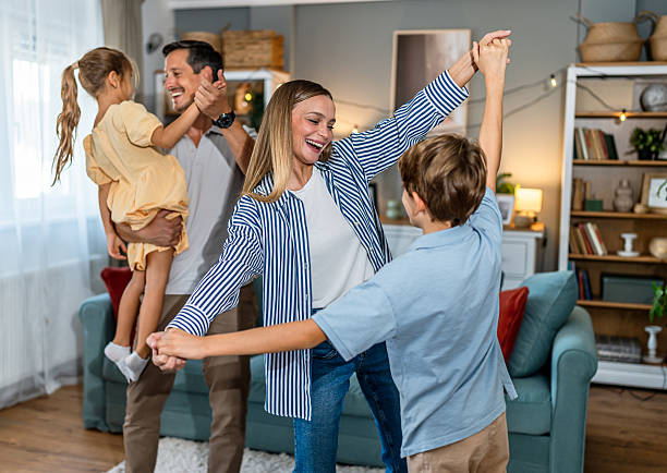istock Happy family dancing together at home, having fun 2241404007