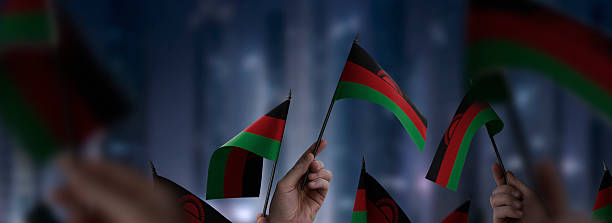 istock Malawi flags in their hands on a blurred urban background 2241404134