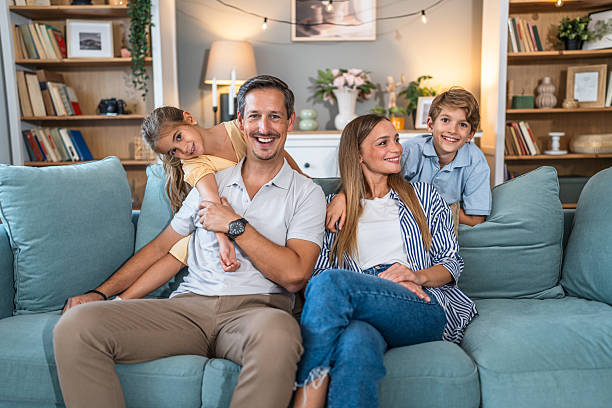 istock Happy family relaxing at home on couch 2241404198