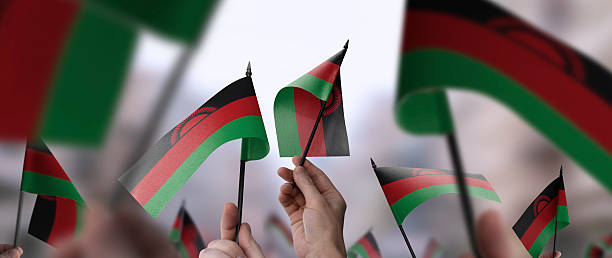istock Malawi flags in their hands on a blurred urban background 2241404556