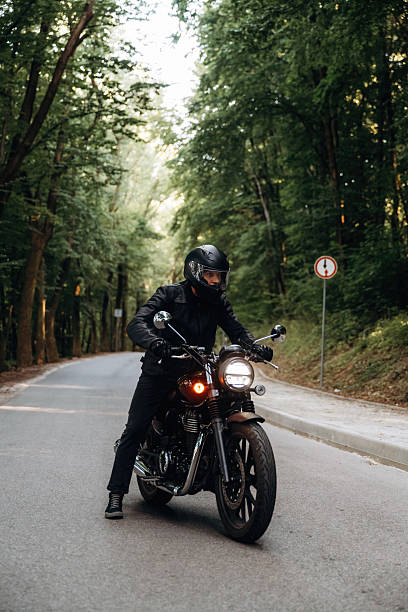 istock In leather clothes. Man is on motorcycle is on the road 2241405182