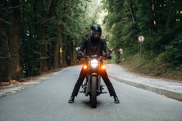 istock In leather clothes. Man is on motorcycle is on the road 2241405195