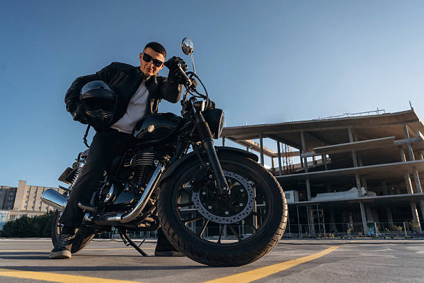 istock Bright sunlight, parked. Man is outdoors with his motorcycle 2241405951
