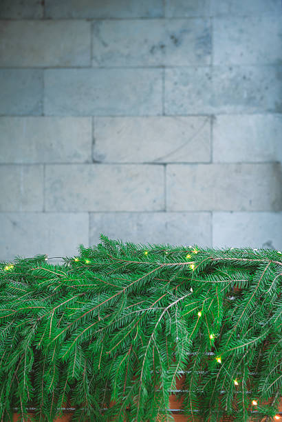 istock Green pine branches lie under a stone wall creating Christmas natural texture 2241406972